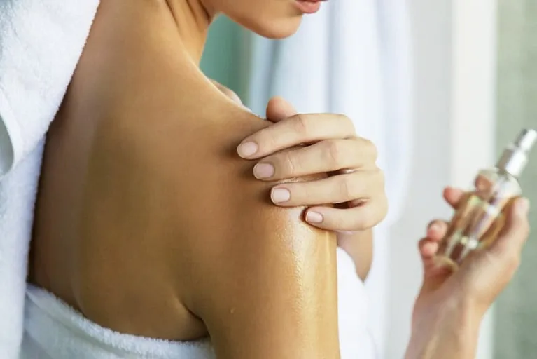 Manos aplicando autobronceante sobre la piel de forma uniforme